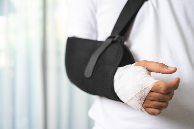 包帯を巻いた腕にサポーターをしている男性